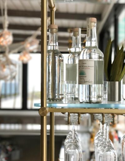 A bar cart with several bottles on it.